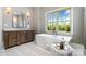 Relaxing bathroom featuring a soaking tub, wooden vanity, and a large window at 4008 Nettie Ct # 3, Charlotte, NC 28211