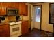 Kitchen featuring white appliances, wood cabinets, and access to the backyard through a door at 522 Perry St, Troy, NC 27371