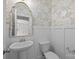 Charming half-bathroom featuring a pedestal sink, decorative mirror, and patterned wallpaper at 531 Harlech Ct, Fort Mill, SC 29715