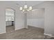 Open dining room area with modern chandelier and wood floors, seamlessly connecting to the kitchen and living spaces at 531 Harlech Ct, Fort Mill, SC 29715