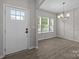 Inviting entryway showcasing a white front door, natural light, and modern light fixtures in the adjacent room at 531 Harlech Ct, Fort Mill, SC 29715