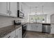 Modern kitchen featuring granite countertops, stainless steel appliances, white cabinets, and subway tile backsplash at 531 Harlech Ct, Fort Mill, SC 29715