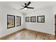Bedroom featuring hardwood floors, multiple windows, and modern fixtures at 5520 Chedworth Dr, Charlotte, NC 28210