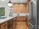 Modern kitchen with stainless steel appliances, wooden cabinets, and a sleek design at 5520 Chedworth Dr, Charlotte, NC 28210