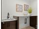 Modern laundry room with sleek countertops, a sink, and built-in appliances at 5520 Chedworth Dr, Charlotte, NC 28210