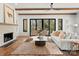 Inviting living room features exposed beams, fireplace, and access to the outdoor patio, creating seamless indoor-outdoor living at 5520 Chedworth Dr, Charlotte, NC 28210