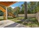 Landscaped backyard featuring a wooden fence, mature tree, and stairs leading to an elevated deck at 5610 Farmbrook Dr, Charlotte, NC 28210