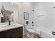 Modern bathroom with a dark wood vanity, white tiled walls, and black fixtures at 5610 Farmbrook Dr, Charlotte, NC 28210