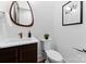 Stylish half bathroom with modern fixtures, a unique mirror, and a dark wood vanity at 5610 Farmbrook Dr, Charlotte, NC 28210