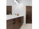 Modern bathroom with double vanity, sleek fixtures, and dark wooden doors at 5610 Farmbrook Dr, Charlotte, NC 28210