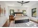 This bedroom features dark wood floors, and a king bed with a modern ceiling fan at 5610 Farmbrook Dr, Charlotte, NC 28210