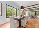 Elegant dining room with a wooden table, cushioned chairs, wood floors, and natural light from windows at 5610 Farmbrook Dr, Charlotte, NC 28210