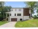 Modern two-story home with a brick and white facade, a brown garage door, and a well-manicured lawn at 5610 Farmbrook Dr, Charlotte, NC 28210