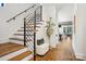 Inviting hallway with hardwood floors, staircase with metal railings, and stylish decor at 5610 Farmbrook Dr, Charlotte, NC 28210