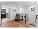 Hallway area shows hardwood floors, a chair and side table, and black metal railings at 5610 Farmbrook Dr, Charlotte, NC 28210
