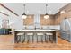 Modern kitchen with wood cabinets, a center island with barstool seating, stainless steel appliances at 5610 Farmbrook Dr, Charlotte, NC 28210