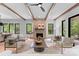 Spacious living room boasts wood beams, brick fireplace, modern furnishings, and large windows with natural light at 5610 Farmbrook Dr, Charlotte, NC 28210