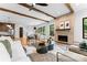Inviting living room featuring a brick fireplace, ceiling beams, and modern furnishings at 5610 Farmbrook Dr, Charlotte, NC 28210