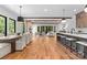 Open floor plan with a dining area, kitchen, and living room with exposed wood beams and hardwood floors at 5610 Farmbrook Dr, Charlotte, NC 28210