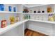Walk-in pantry features organized shelving with a variety of food and beverage items, and hardwood floors at 5610 Farmbrook Dr, Charlotte, NC 28210
