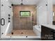 An expansive walk-in shower has unique tiling, a bench seat, and a glass enclosure at 5610 Farmbrook Dr, Charlotte, NC 28210