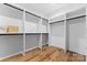 Spacious walk-in closet boasts custom shelving and hardwood floors for organized storage at 5610 Farmbrook Dr, Charlotte, NC 28210