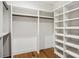 A walk-in closet features custom white shelving and wood flooring at 5610 Farmbrook Dr, Charlotte, NC 28210