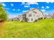Spacious backyard with lush lawn, mature trees, and a covered porch with staircase at 6022 Candlestick Ln, Lancaster, SC 29720