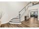 Elegant foyer boasts hardwood floors, a staircase with white railings, and a glimpse into the inviting living area at 6022 Candlestick Ln, Lancaster, SC 29720