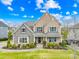 Inviting two-story home boasts a manicured lawn, stone accents, and charming curb appeal under a bright, cloudy sky at 6022 Candlestick Ln, Lancaster, SC 29720