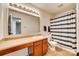 Bathroom featuring a spacious vanity, large mirror, and shower with blue striped curtain at 6523 Matlea Ct, Charlotte, NC 28215