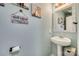 Charming half bath with unique decor, including whimsical wall art and a pedestal sink, adding character to the space at 6523 Matlea Ct, Charlotte, NC 28215