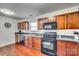This kitchen features wooden cabinets, black appliances, and mosaic tile backsplash, creating a modern and functional cooking space at 6523 Matlea Ct, Charlotte, NC 28215