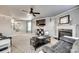 Stylish living room with a modern fireplace, ceiling fan, and open staircase at 6523 Matlea Ct, Charlotte, NC 28215