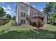 Large backyard with a tiered deck, manicured lawn, and mature trees, perfect for outdoor living at 705 Drew Ave, Fort Mill, SC 29708