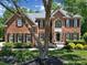 Charming brick home featuring a well-manicured lawn and classic architectural details, framed by a mature tree at 705 Drew Ave, Fort Mill, SC 29708
