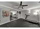 Home gym featuring mirrored wall, TV, ceiling fan and modern workout equipment at 705 Drew Ave, Fort Mill, SC 29708