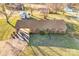 Overhead view of a brick ranch-style home with a carport, set on a lot dotted with trees and outbuildings at 7270 Long Island Rd, Catawba, NC 28609