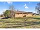 Back exterior view of brick home, metal roof, well-maintained lawn, and partially covered patio area at 7270 Long Island Rd, Catawba, NC 28609