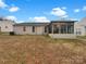 View of the backyard with a sunroom addition, offering ample outdoor space with an exterior unit in view at 7926 Sir Barton Ct, Charlotte, NC 28215