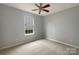 Neutral bedroom with a fan and natural light from the window at 7926 Sir Barton Ct, Charlotte, NC 28215
