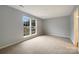 Bright bedroom features a large window and neutral carpet at 7926 Sir Barton Ct, Charlotte, NC 28215