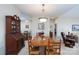 Dining room showing wooden table, adjacent kitchen view, china cabinet, and cozy armchair in connected open floor plan at 8568 Windsor Ridge Dr, Charlotte, NC 28277