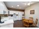 Bright kitchen area with a white countertop, white appliances, dark wood-look floors, and a wooden dining table with chairs at 8568 Windsor Ridge Dr, Charlotte, NC 28277