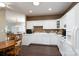 Open kitchen featuring white cabinets, countertops, and appliances, with views into the adjoining dining and living areas at 8568 Windsor Ridge Dr, Charlotte, NC 28277