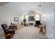 Spacious living room with vaulted ceilings, neutral carpet, traditional furnishings, fireplace and arched windows at 8568 Windsor Ridge Dr, Charlotte, NC 28277
