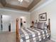 Inviting main bedroom with a beautiful tray ceiling, a wooden bed frame, and an ensuite bathroom at 8568 Windsor Ridge Dr, Charlotte, NC 28277
