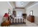 Comfortable main bedroom features a tray ceiling, a wooden bed frame, and classic decor at 8568 Windsor Ridge Dr, Charlotte, NC 28277