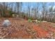 Wooded backyard with a shed, firepit with chairs, and a playset with a slide and swings at 946 Laurelwood Dr, Clover, SC 29710