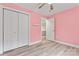 A pink bedroom with a closet and door with a ceiling fan and hardwood floors at 946 Laurelwood Dr, Clover, SC 29710
